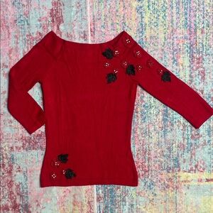 Elegant Red Off-the-Shoulder Sweater with Black Floral Embellishments
